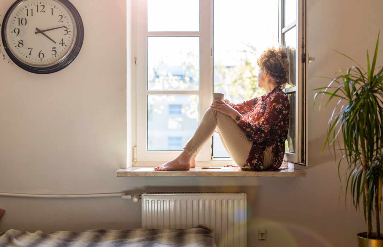 Frau genießt Luft am Fenster